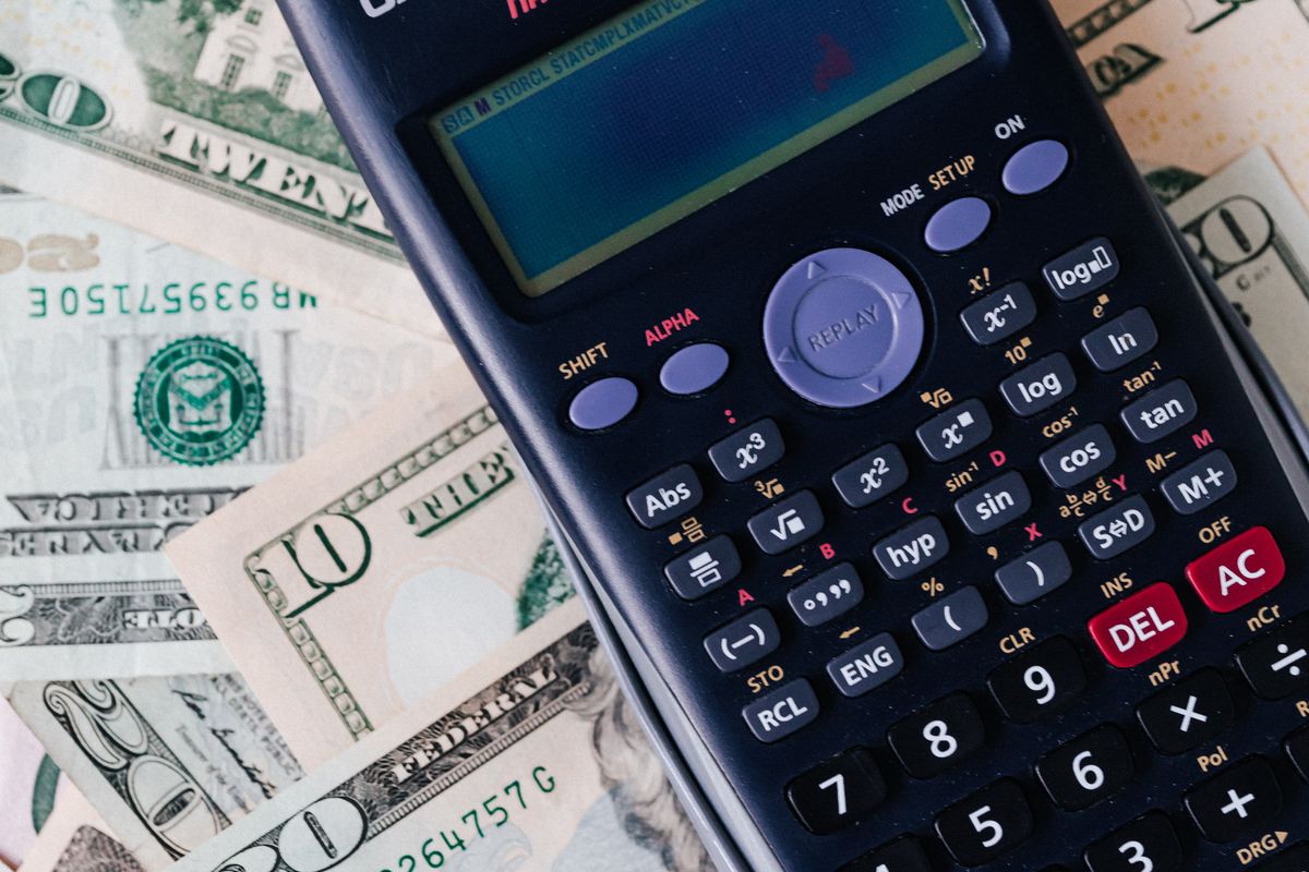 Calculator sitting on a stack of banknotes