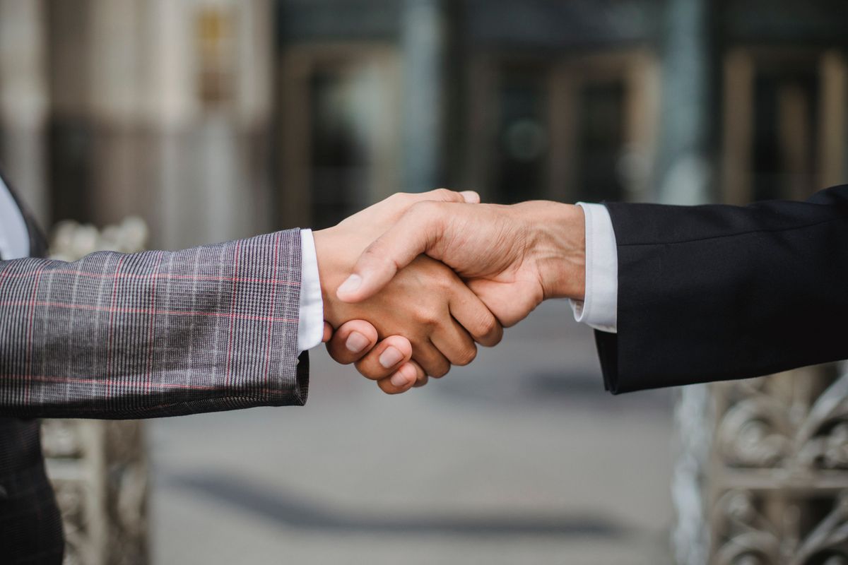 Two people shaking hands at a meeting